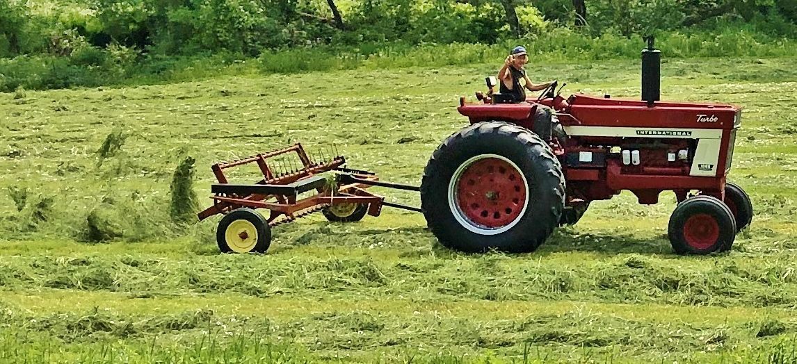 Farmer works in field with old tractor
